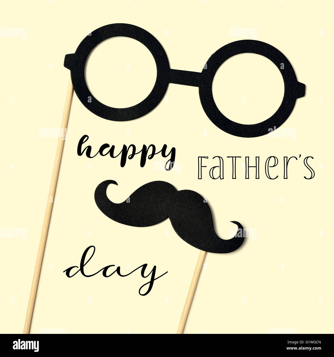 the text happy fathers day and a pair of round-framed eyeglasses and a mustache attached to handles depicting a man face, on a b Stock Photo