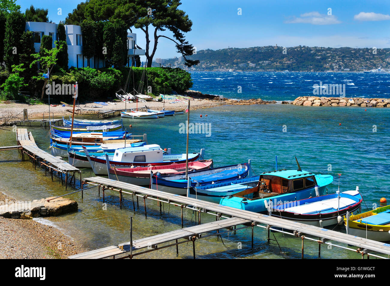 view of some fishing boats moored in a small cave in the Mediterranean sea, in the French Riviera, France Stock Photo