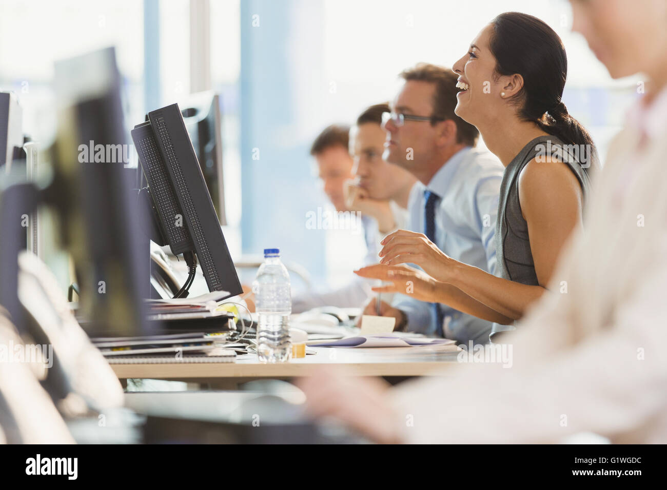 Laughing businesswoman working at computer in office Stock Photo