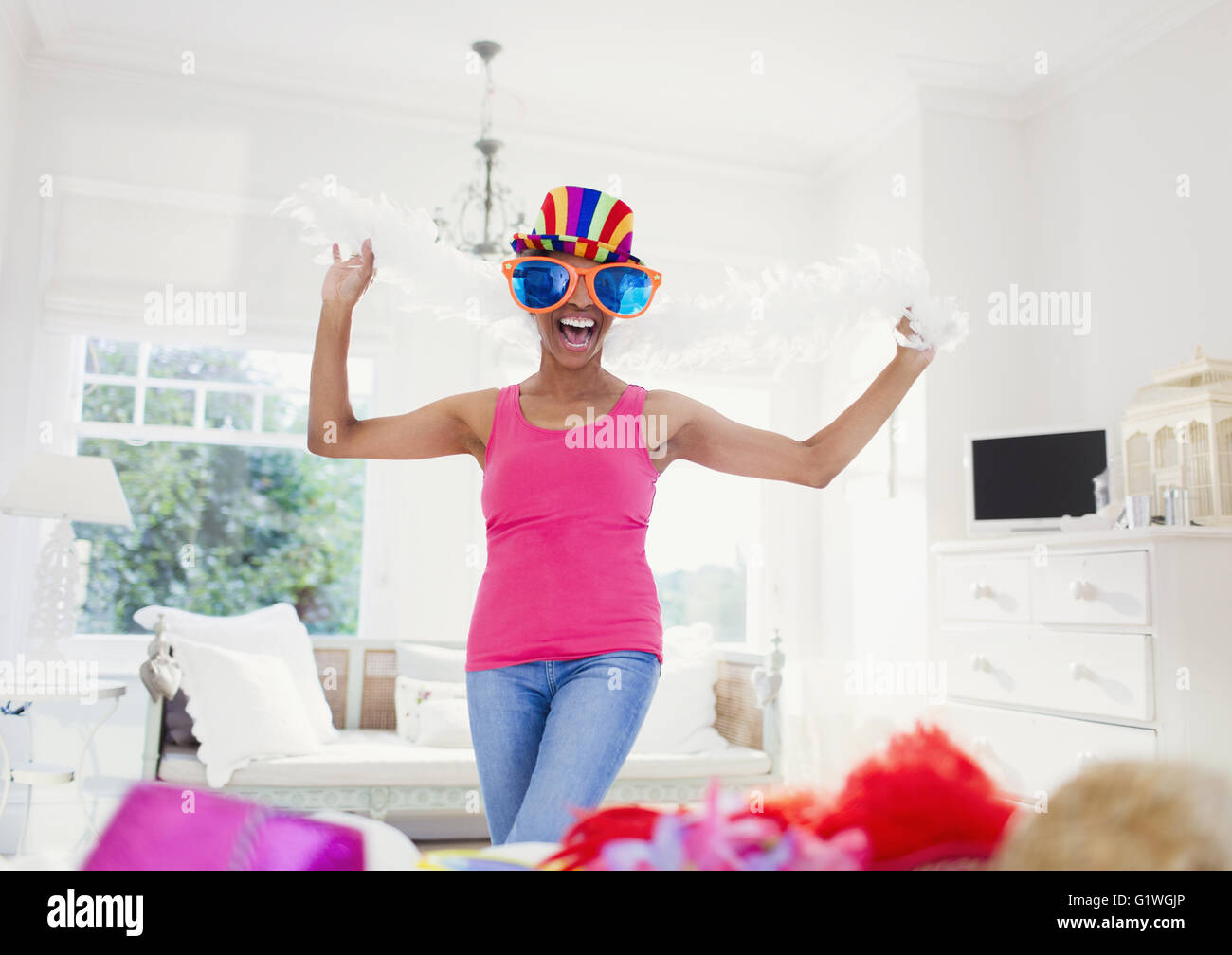 Portrait enthusiastic mature woman wearing feather boa and large sunglasses Stock Photo