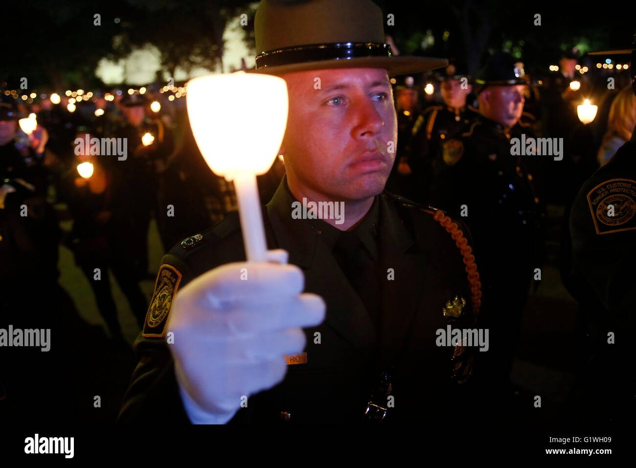 A U.S. Border Protection agent holds a candle alongside fellow law enforcement officers and family members during a candlelight vigil held in memory of fallen officers on the National Mall May 13, 2016 in Washington, DC. Stock Photo
