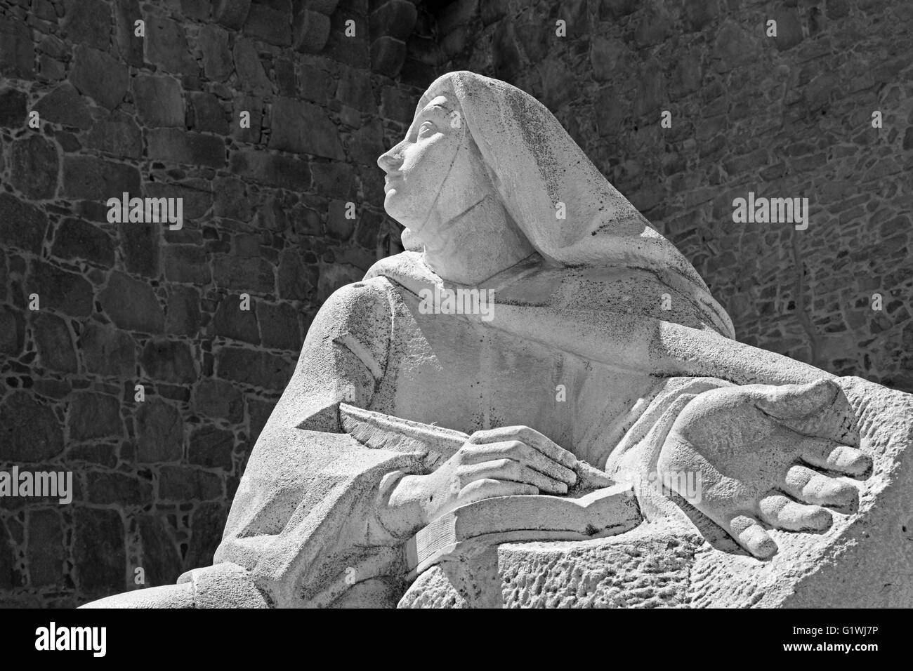 AVILA, SPAIN, APRIL,18, 2016: The statue of St. Theresia of Avila behind the town walls by the Spanish sculptor Juan L. Vassalo Stock Photo