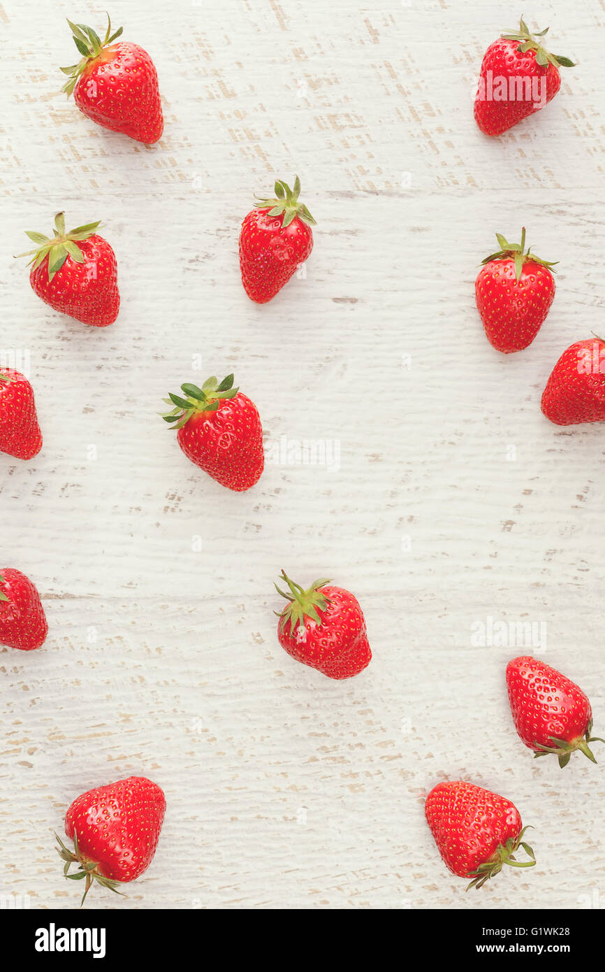 Strawberry background. Fresh strawberries scattered on rustic table Stock Photo