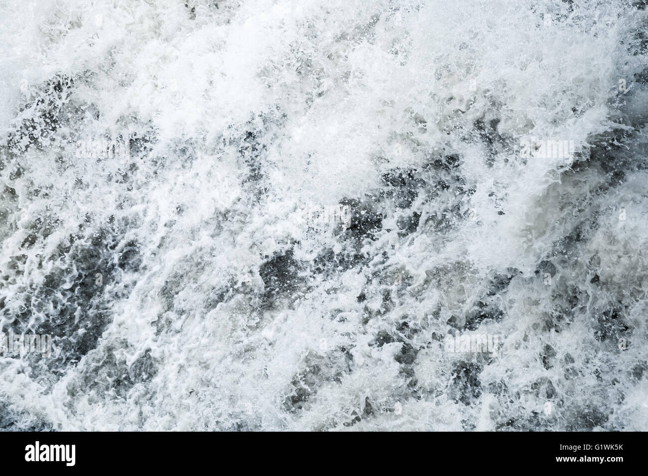 Blue stormy water with splashes and foam, fast river, natural background texture Stock Photo