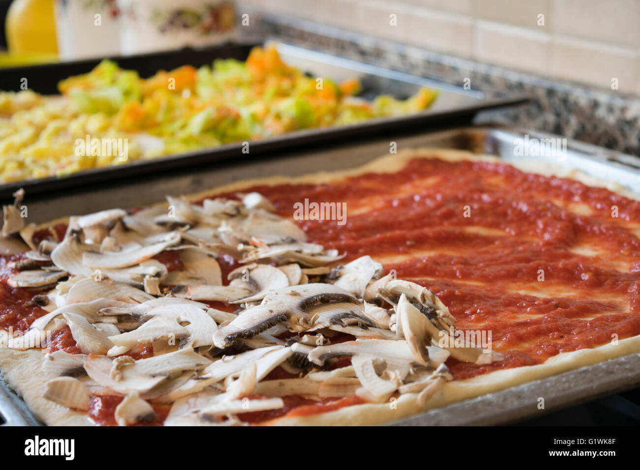 home made dough pizza in a domestic baking tray Stock Photo