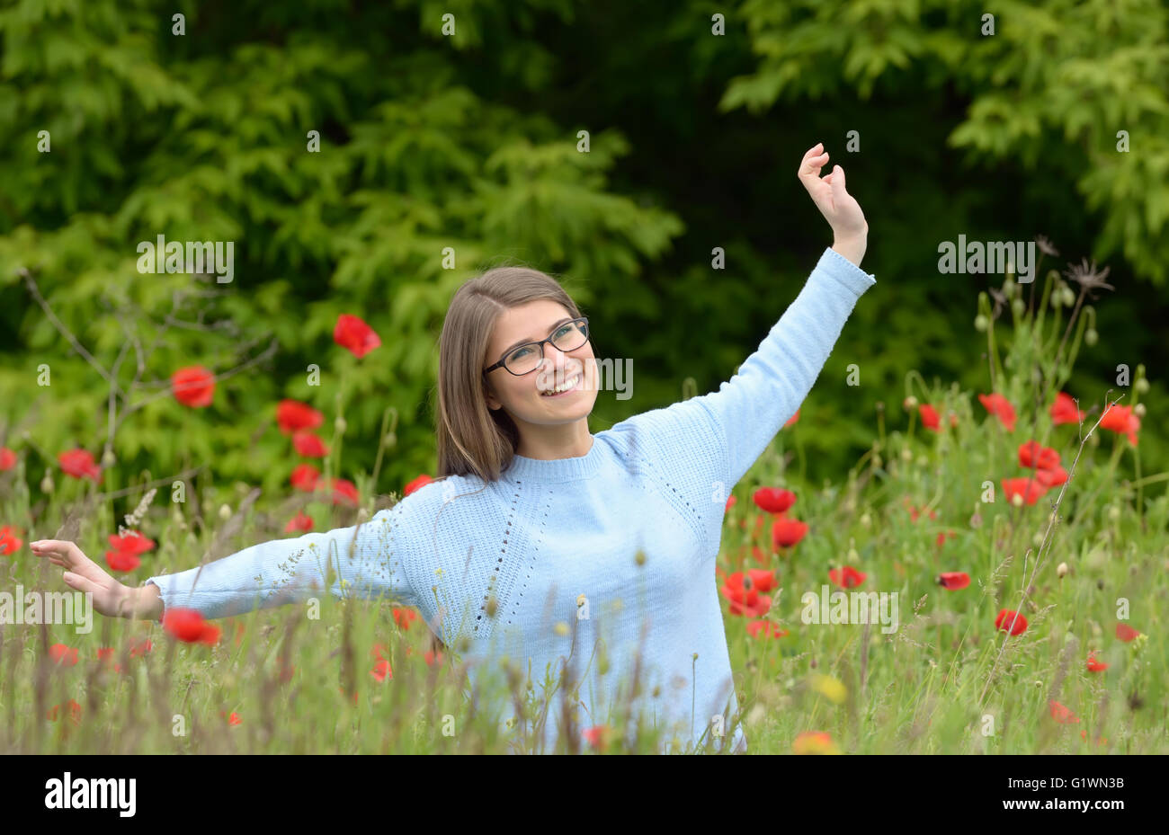 Young girl playing in a poppy field Stock Photo
