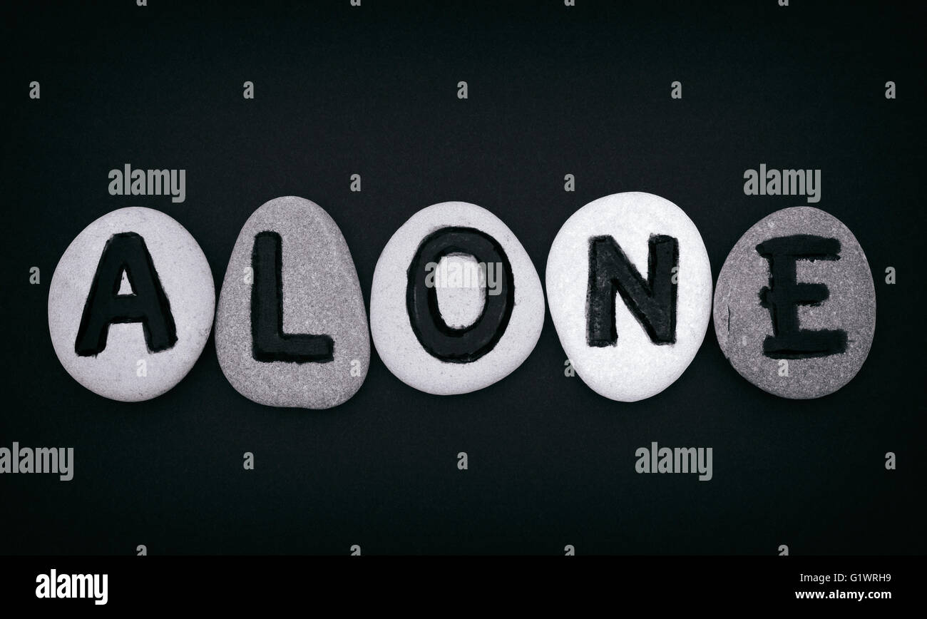 Word Alone spell out from stones with letters and black background