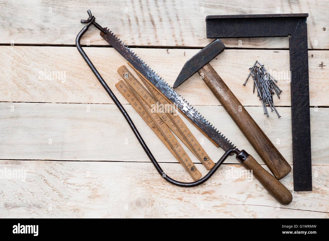 Carpenter tools hammer, nails, tape measure and saw on wood. Space on