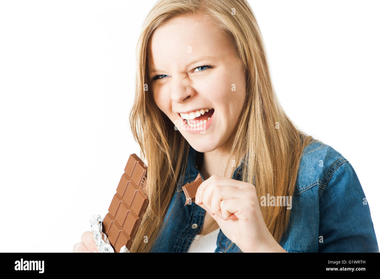Girl biting a bar of chocolate Stock Photo