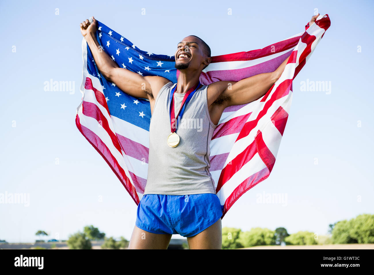 Athlete posing with american flag and gold medals around his neck Stock ...