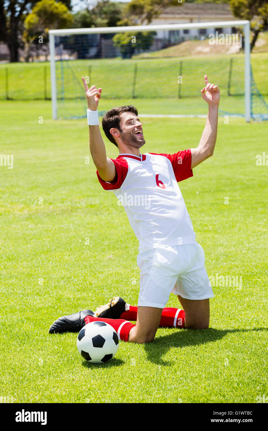 Excited football player kneeling in stadium Stock Photo Alamy