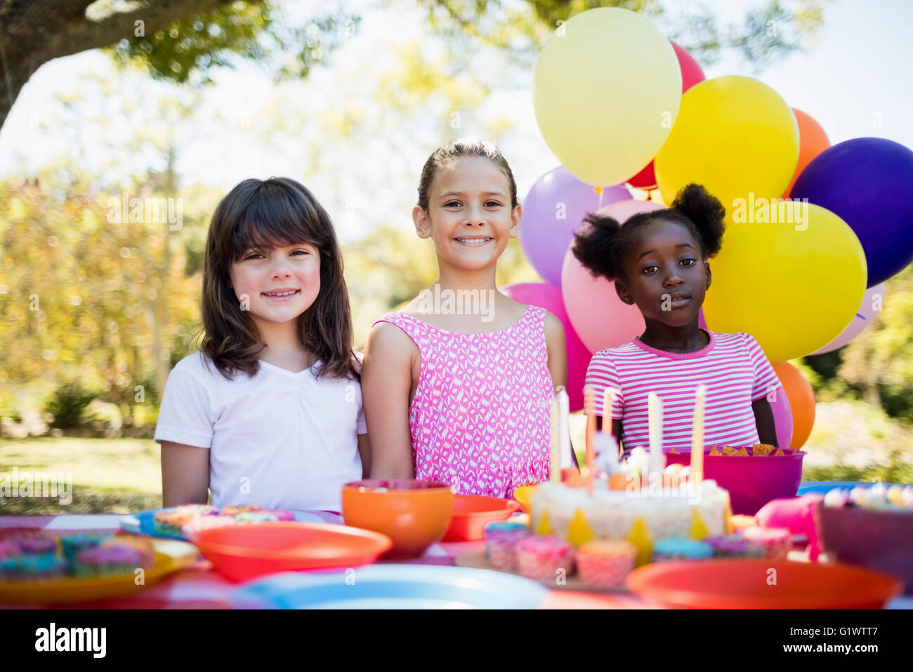 Cute girls smiling and posing during a birthday party Stock Photo