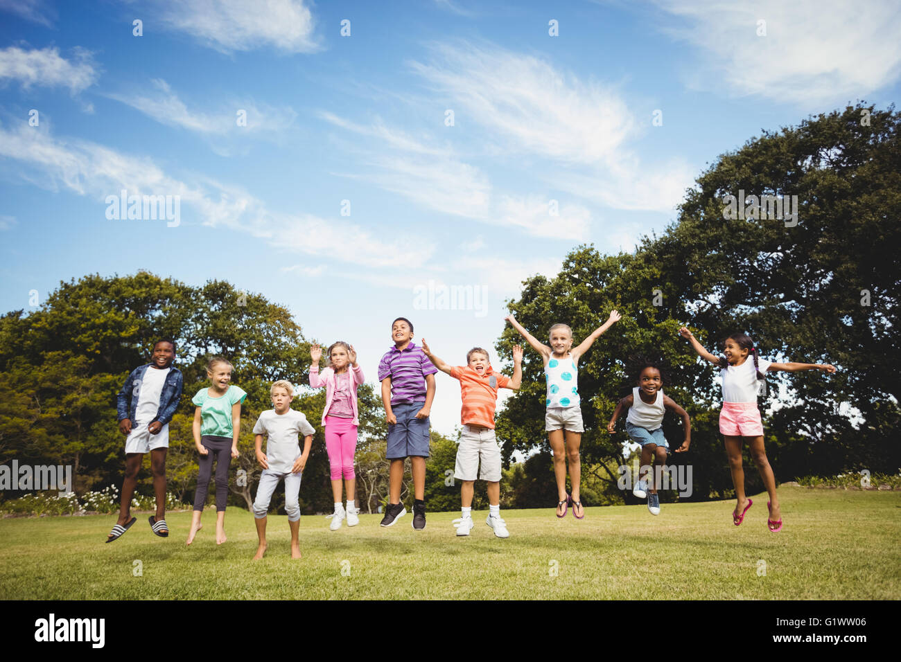 Children jumping in air in park hi-res stock photography and images - Alamy
