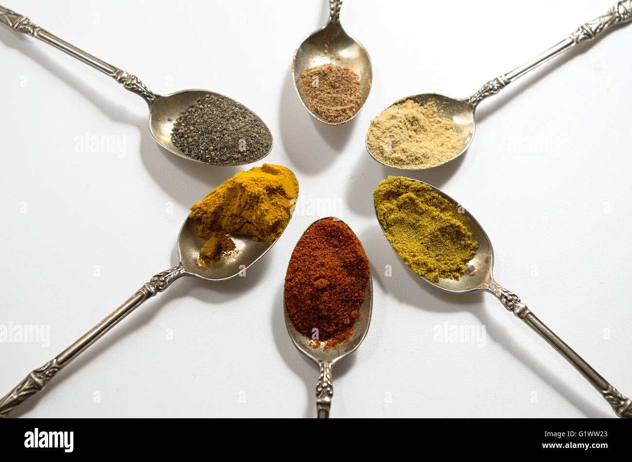 Various spices on vintage silver spoons Stock Photo