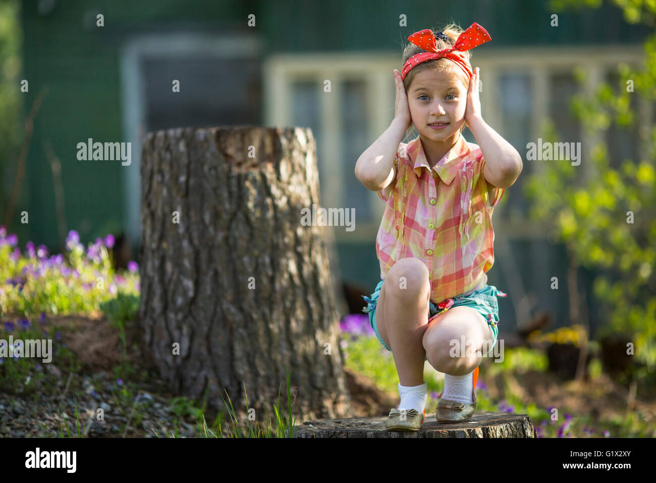 Little cute girl covering her ears with her hands. See Nothing, Hear