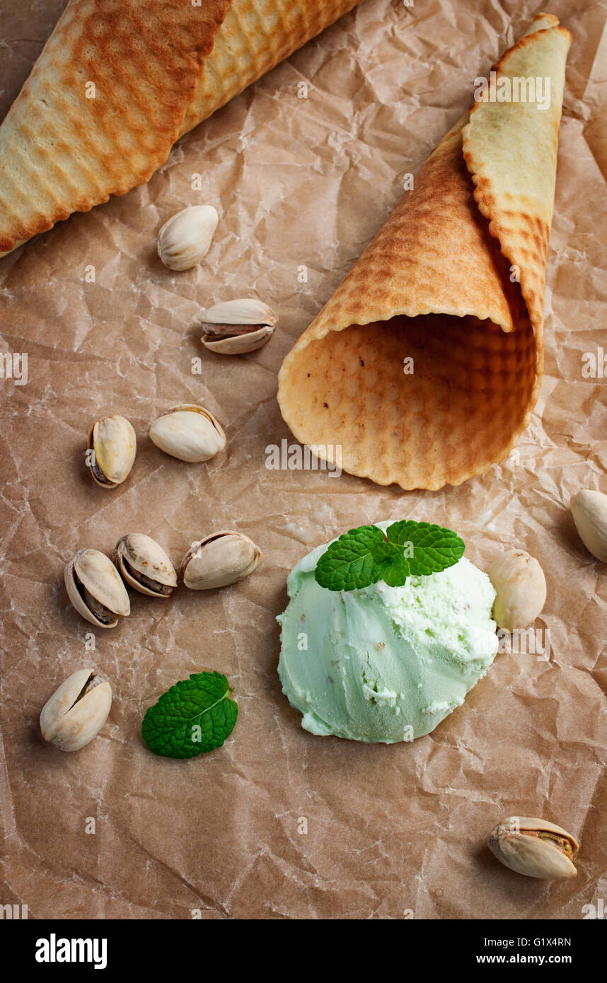 Scoop of pistachio ice cream and waffle cone on parchment paper Stock ...
