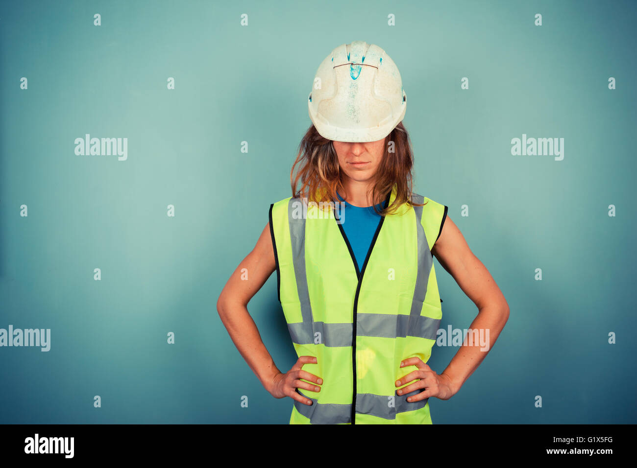 A Young Female Engineer Is Wearing A High Vis Vest And A Hardhat Stock