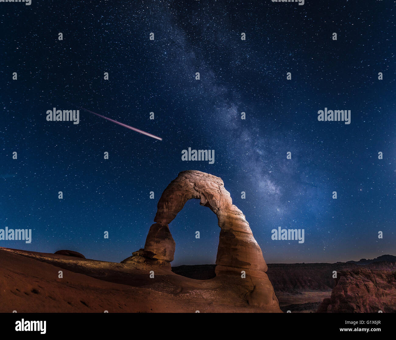 Natural Arch Delicate Arch with Milky Way and shooting star at night, Arches National Park, Moab, Utah, USA Stock Photo