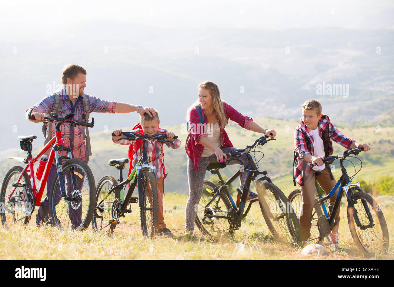 Family of four people riding bikes in the mountains Stock Photo