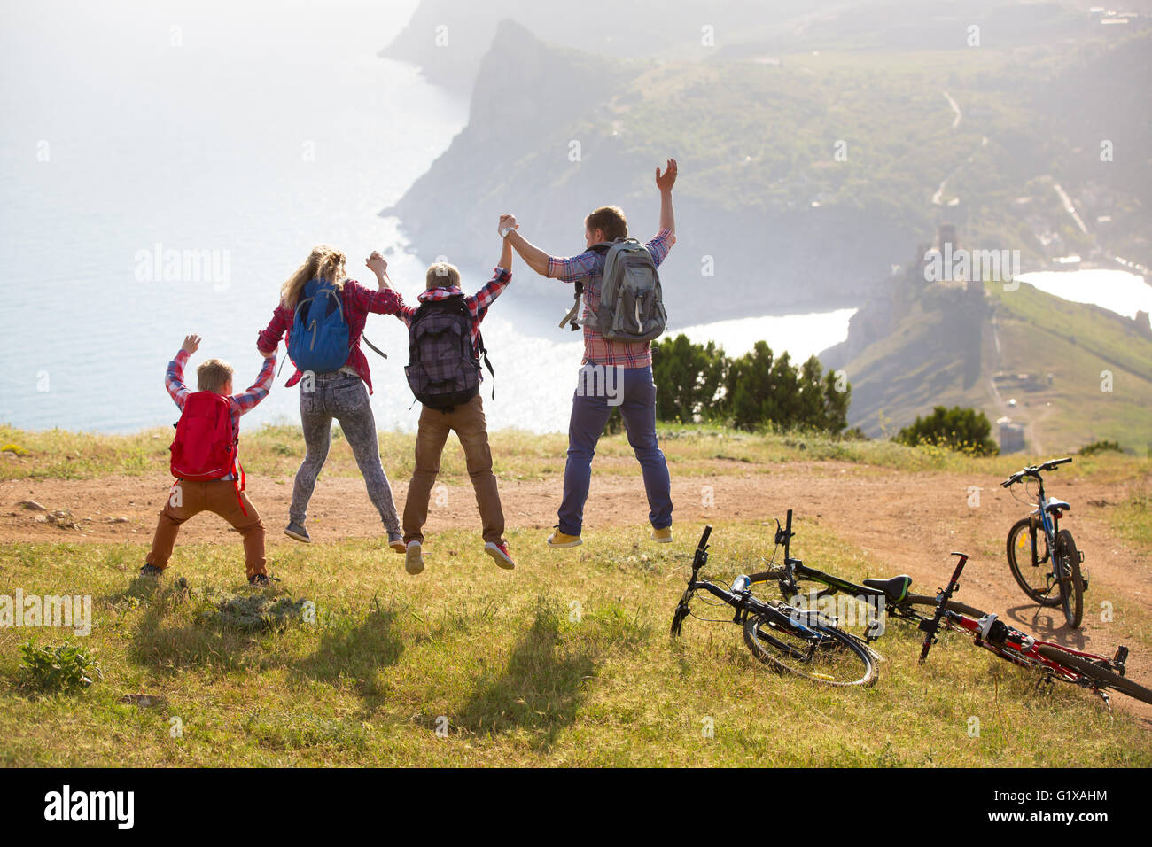 Family of four people with bikes in the mountains Stock Photo