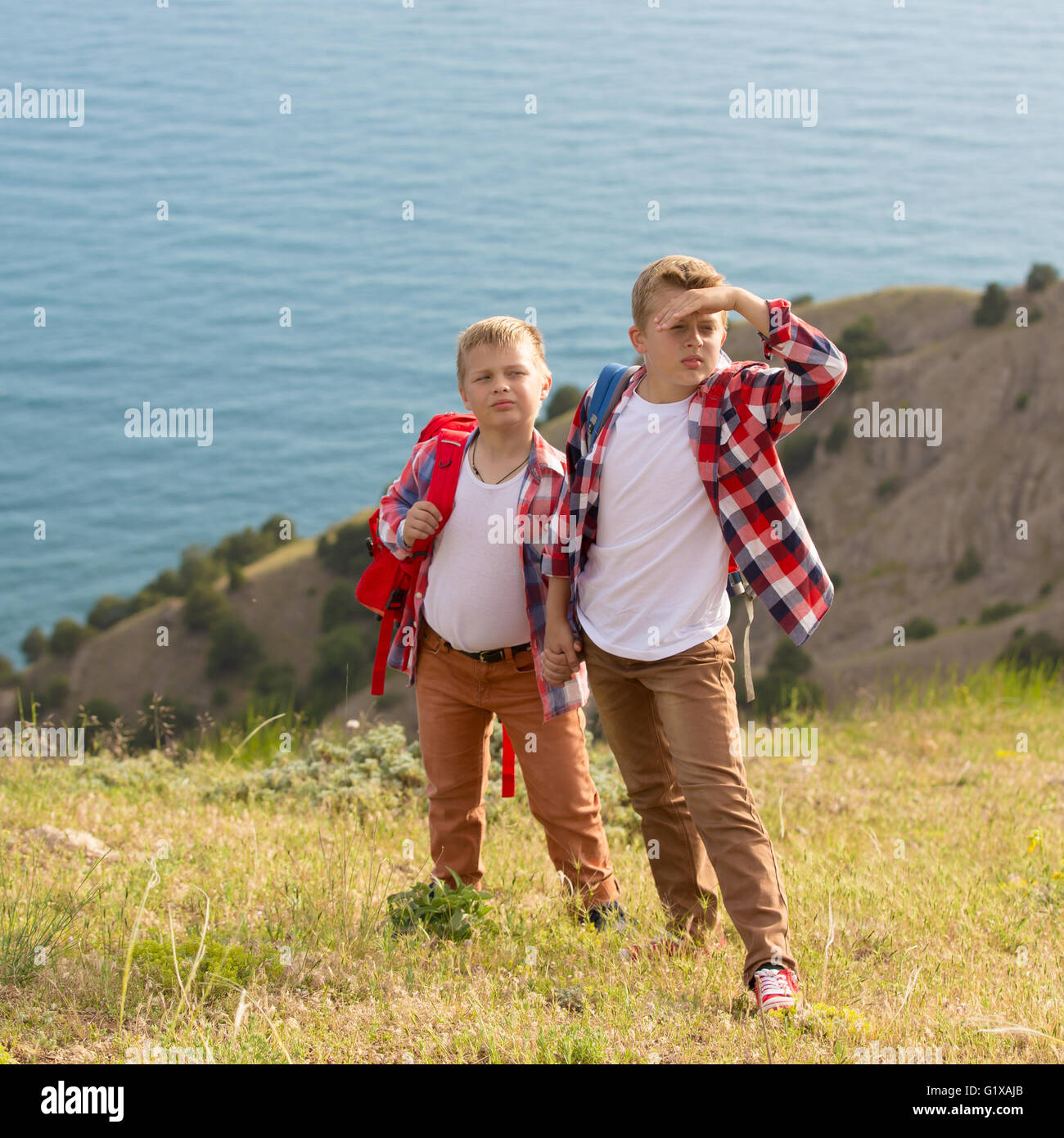 Two brothers walking in mountains near the sea Stock Photo