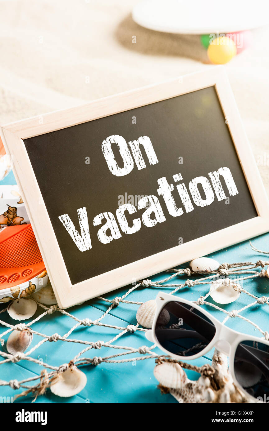 Beach with holiday gear and a board with the words On Vacation Stock Photo