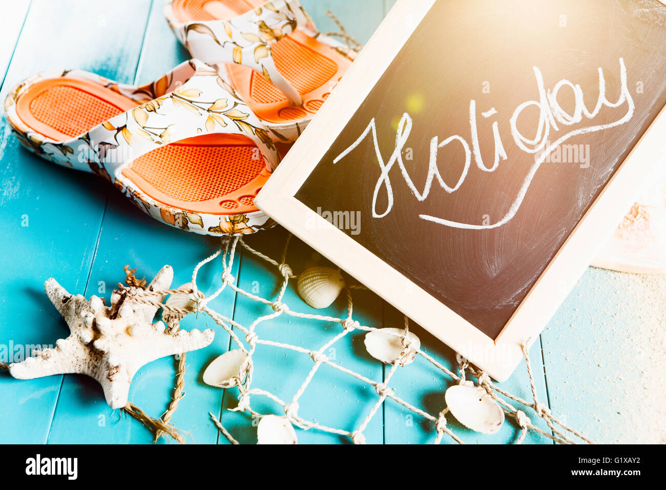 Beach with holiday gear and a board with the word Holiday Stock Photo