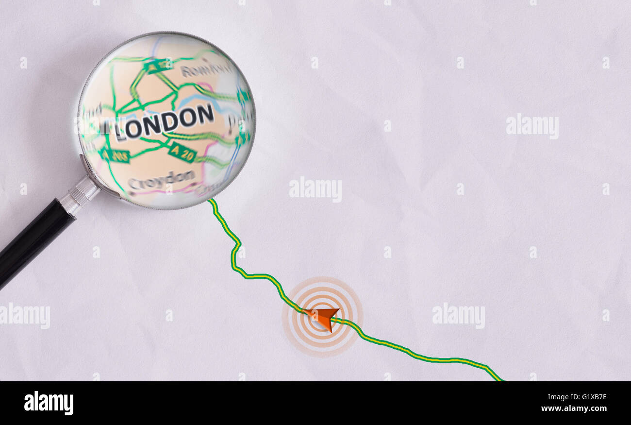 Route on sheet of paper with GPS symbology and magnifying glass highlighting London. Concept travel route Stock Photo