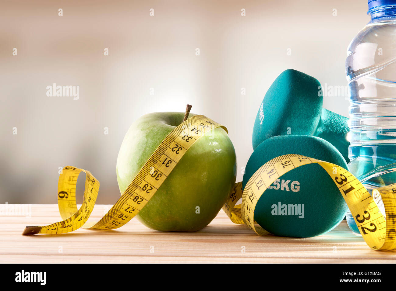https://c8.alamy.com/comp/G1XBAG/dumbbells-with-apple-mineral-water-bottle-and-tape-measure-on-wood-G1XBAG.jpg