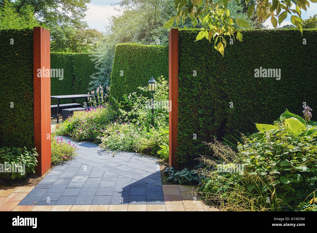 Sitting area in the garden enclosed by hedges. Stock Photo