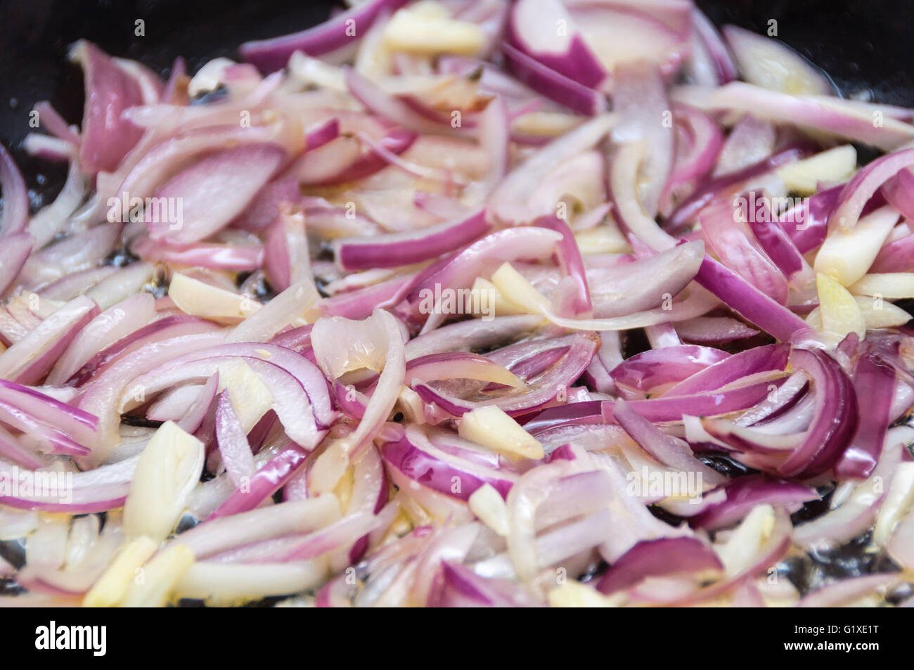 Cooking red onions and garlic in a pan Stock Photo Alamy