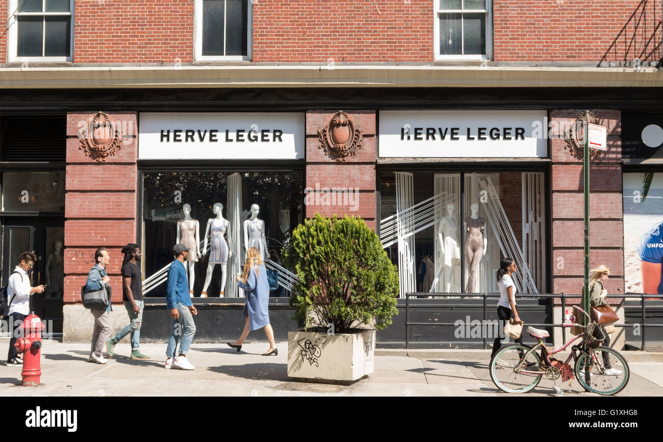 Exterior street view of Herve Leger store with people walking past the store front in Soho, New York City Stock Photo