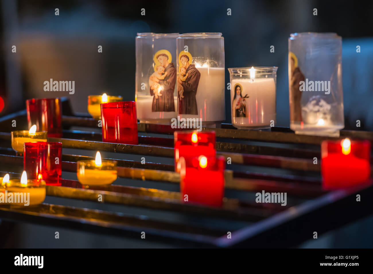Shallow focus image of colorful candles at medieval cathedral altar Stock Photo