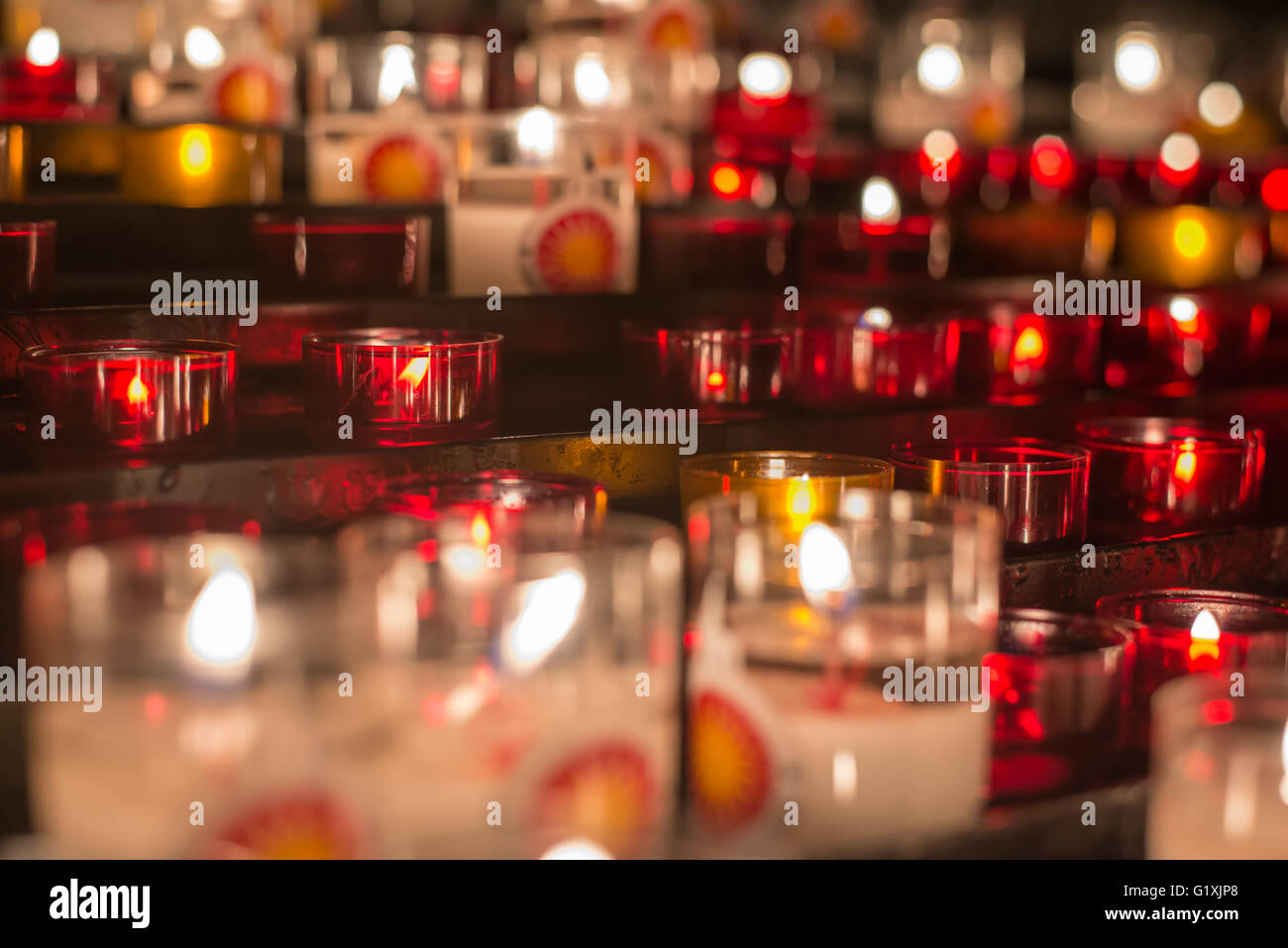 A lot of colorful candles at medieval altar, low key shallow focus