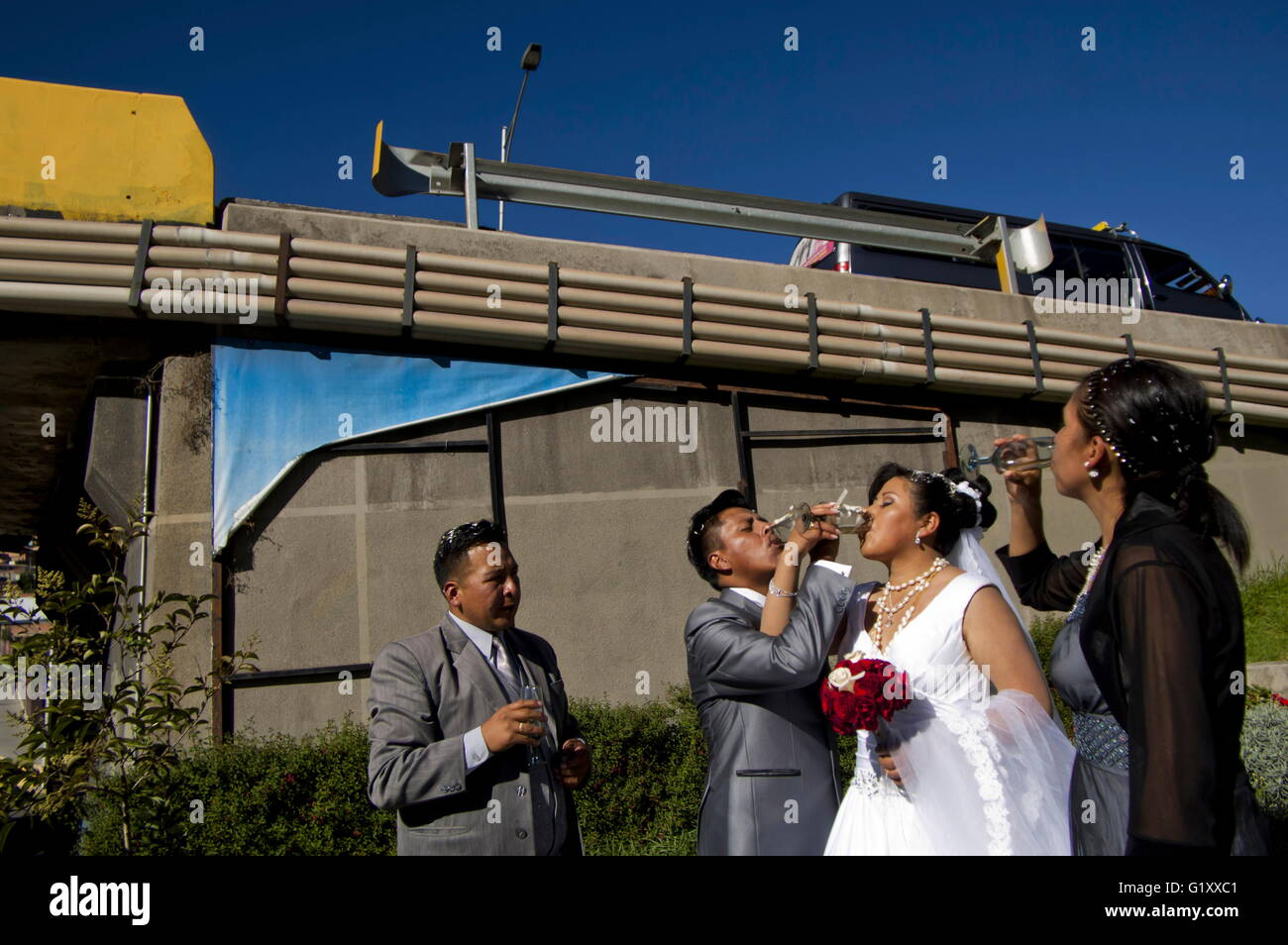 Apr 16, 2016 - La Paz, Bolivia - Weddings in the triple bridges. In La Paz, Bolivia, marriage is still considered as the economical alliance between families in the old spanish way. La Paz and El Alto most of them indigenous families get the wedding business as a very serious thing. One of the principal step for just married is going through one, two or three of the recent built continuous three bridges going from west to east canyons of the accident city. It's a way to seal a kind of pact between families and symbolically pass from a celibate life to married one. Get some champagne' (cheap ci Stock Photo