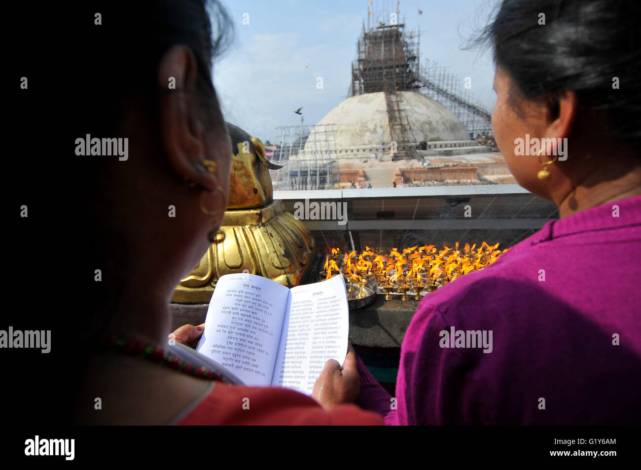Devotee offering rituals prayer at the Boudhanath stupa, one of the largest stupas in the world during celebration the 2,560th Buddha Purnima festival, Birth Anniversary of Lord Gautam Buddha at Boudhanath Stupa, Kathmandu on May 21, 2016. Buddhists around the world, Cambodia; Thailand; Myanmar; Bhutan; Sri Lanka; Laos; Mongolia; Japan; Singapore; Taiwan including Nepal, observe Buddha Purnima festival which falls on the same day of full moon of the month calendar. The occasion offerings of flower, incense and candles, an exchange of gifts as blessings, prayers, sermons and group meditations. Stock Photo