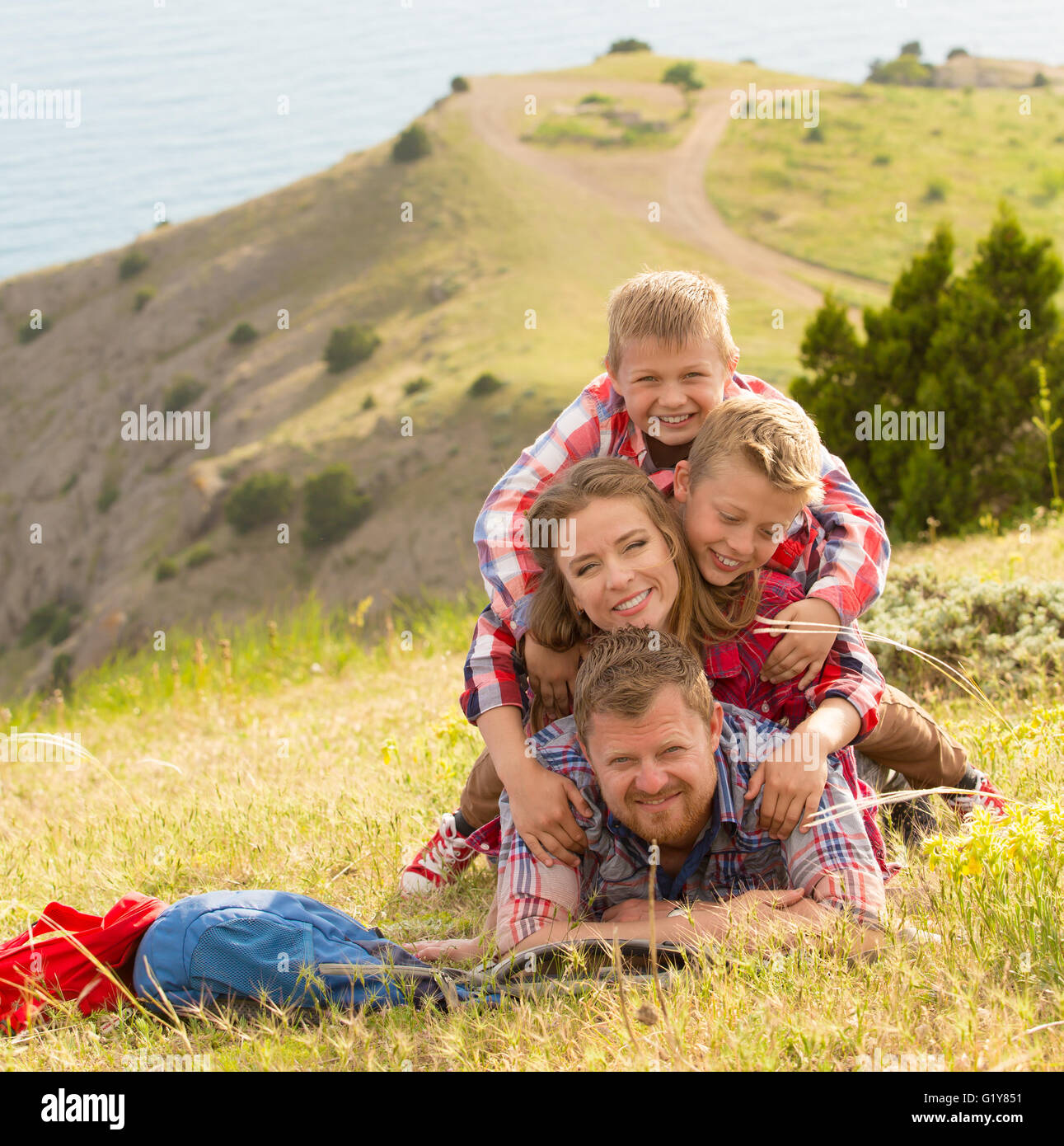 Family of four people looking to beautiful seascape in mountains Stock Photo