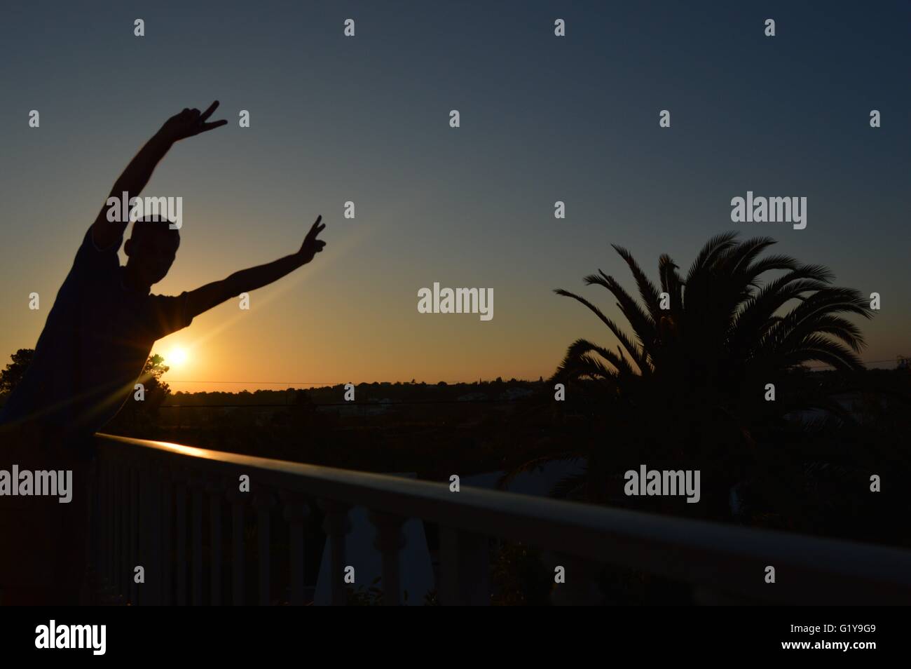 A silhouette of a man next to the rising sun.  Silhouette of head and shoulders Stock Photo