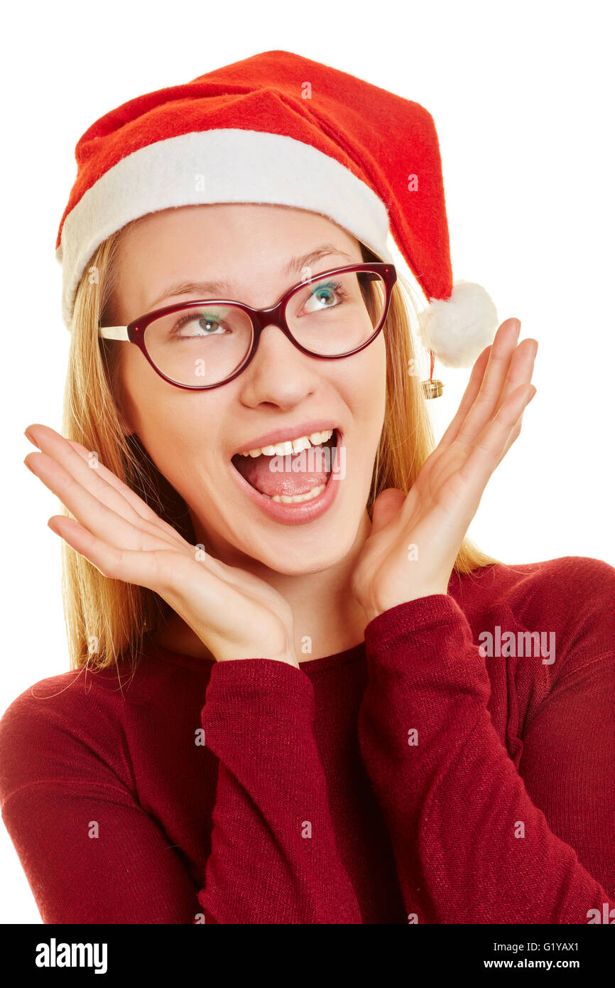 Sorprised young woman at christmas with her hands on her face Stock Photo