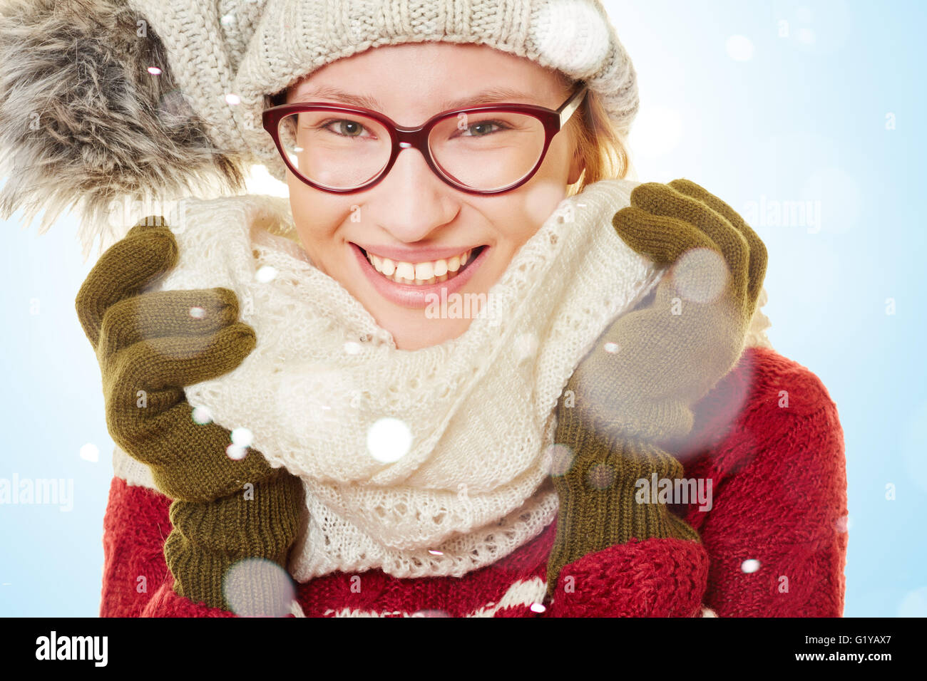 Smiling young woman in the snow in winter wearing winter clothes Stock Photo