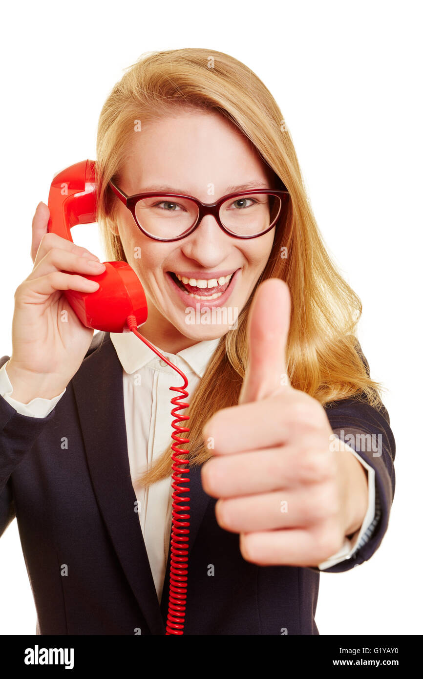 Cheerlful blond businesswoman calling on the phone with her thumb up Stock Photo