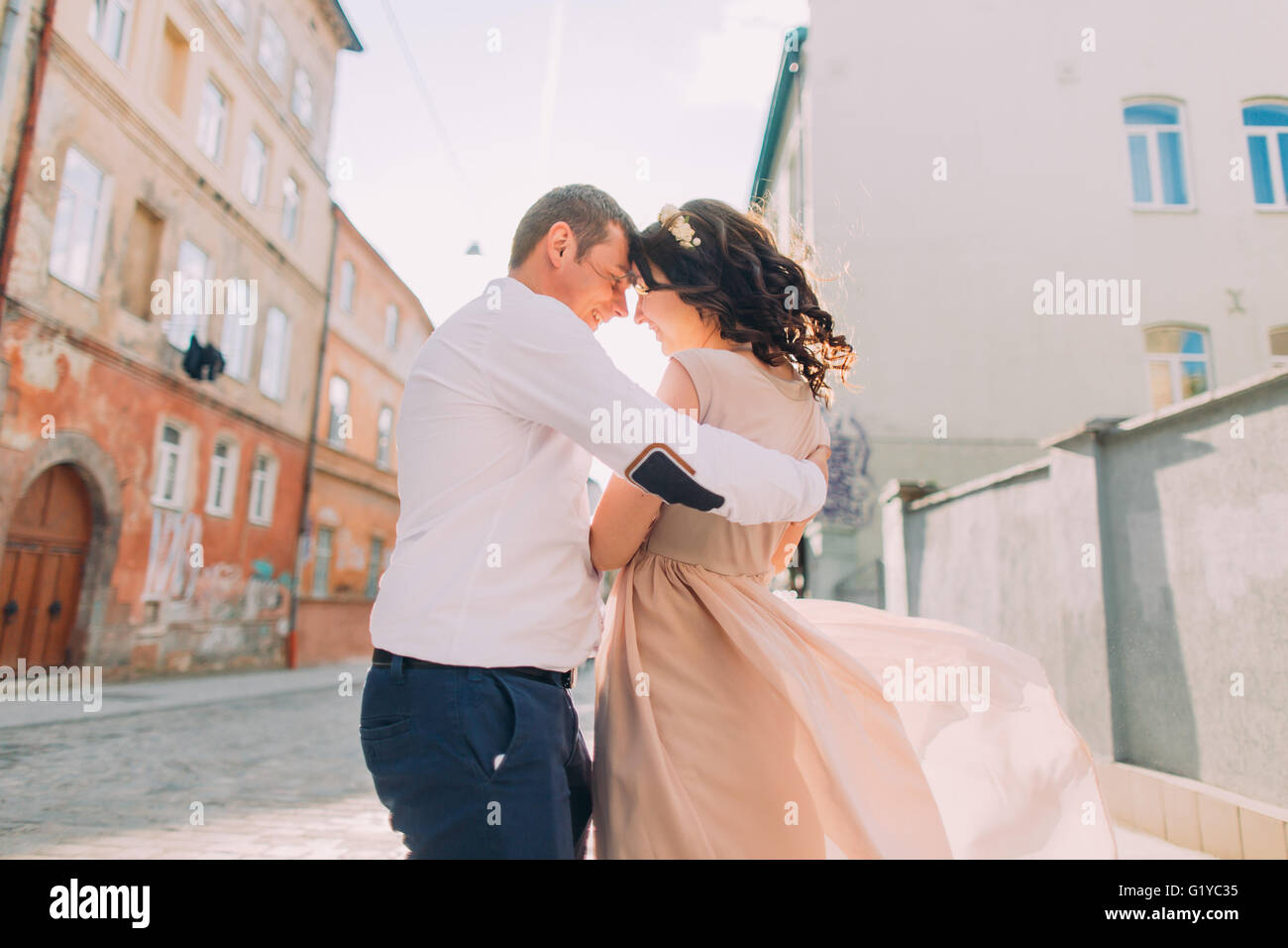 Beautiful bridal couple dancing at sunset on the streets of old city ...