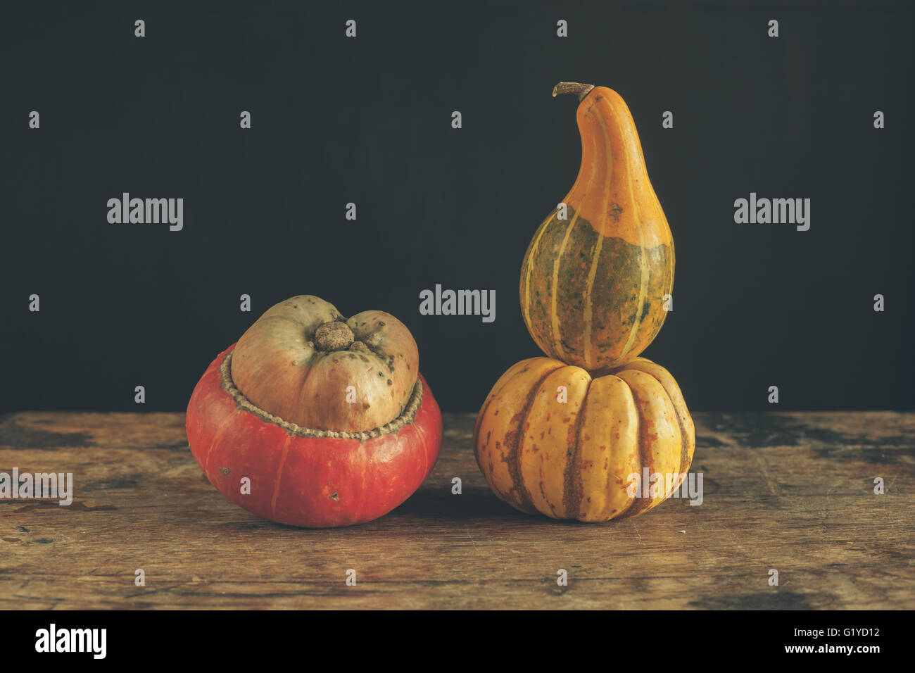 Gourds on a wooden table against a black background Stock Photo - Alamy