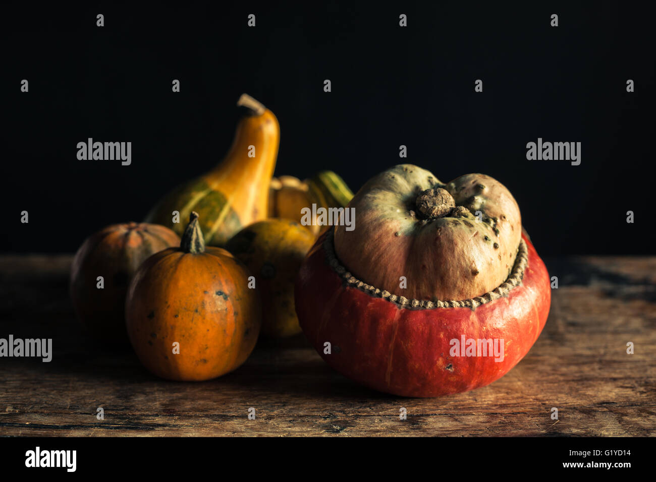 Gourds on a wooden table against a black background Stock Photo - Alamy