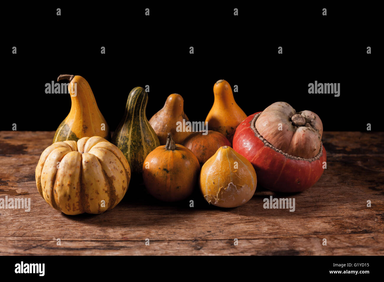 Gourds on a wooden table against a black background Stock Photo - Alamy