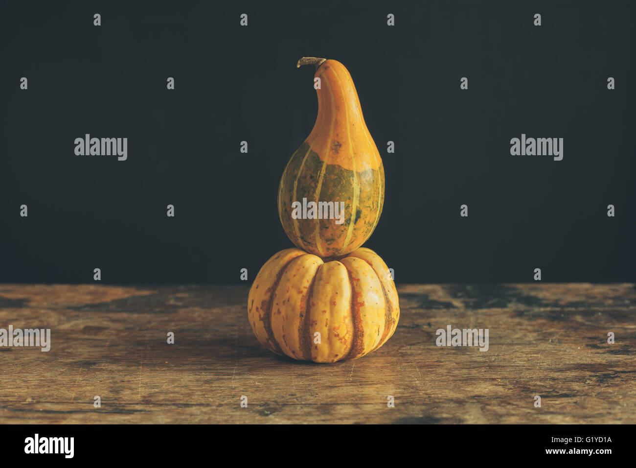 Gourds on a wooden table against a black background Stock Photo - Alamy