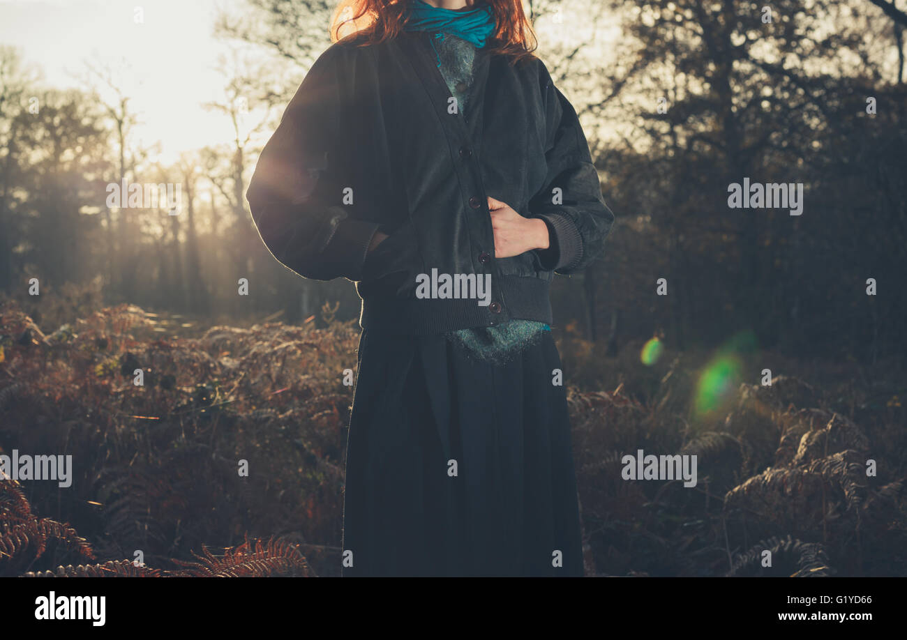 A young woman is standing in the forest at sunset Stock Photo - Alamy