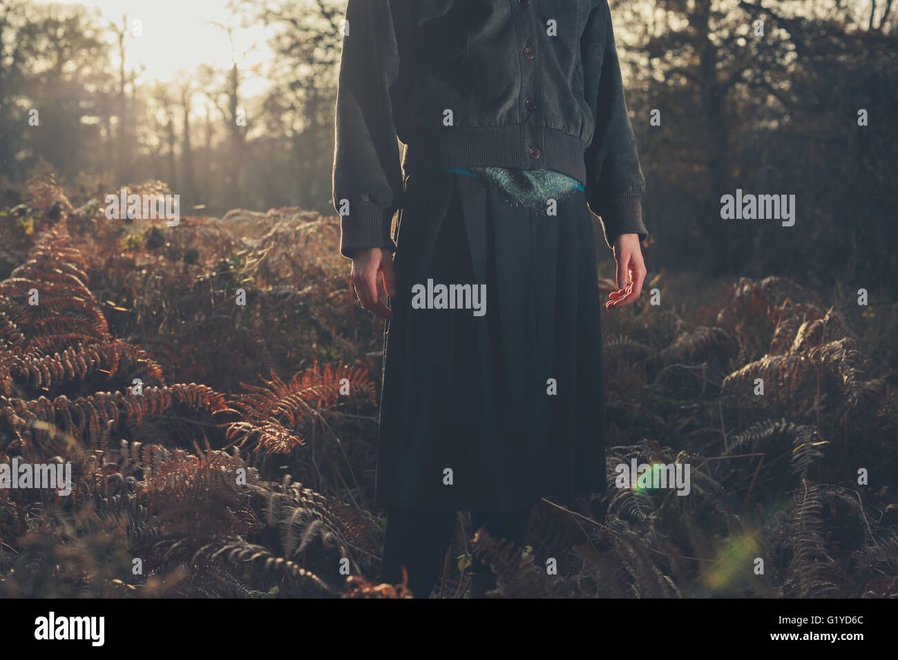 A young woman is standing in the forest at sunset Stock Photo - Alamy