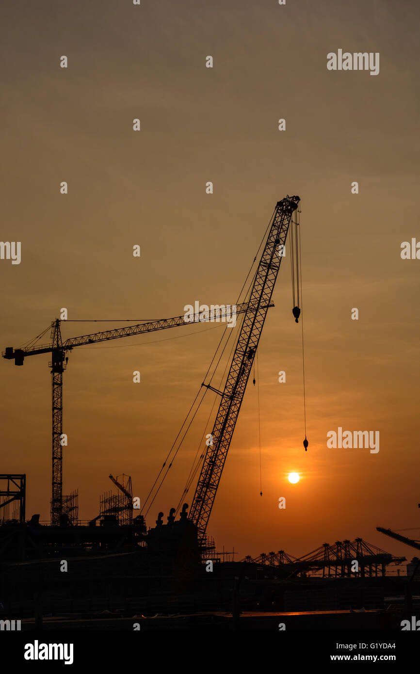 Crane on a construction site at sunset Stock Photo - Alamy