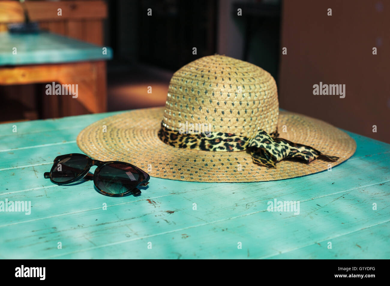 A straw hat and a pair of sunglasses on a table in the sunlight Stock ...